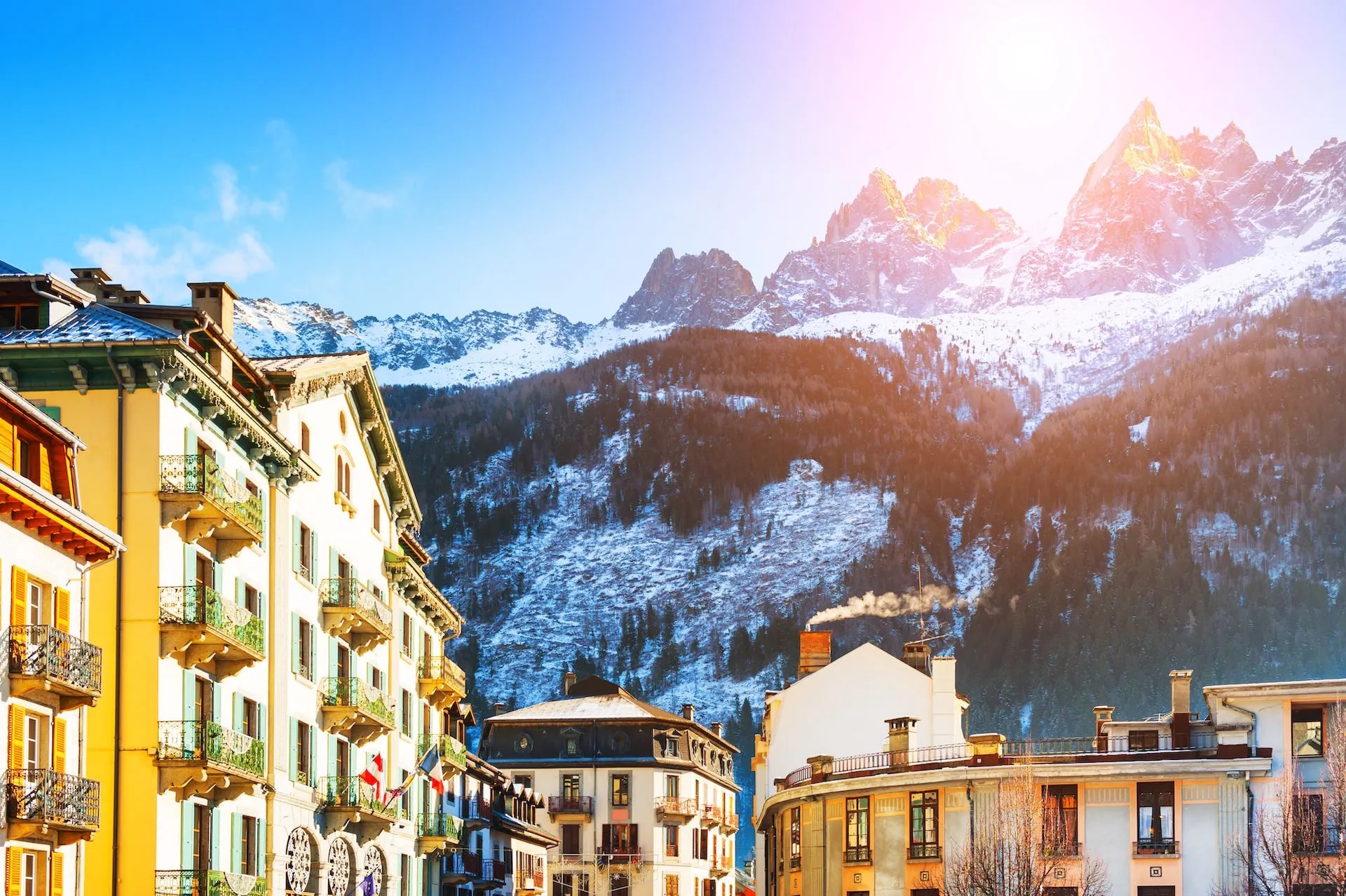 Chamonix-Mont-Blanc alpine village buildings with snow-covered mountains under bright sun
