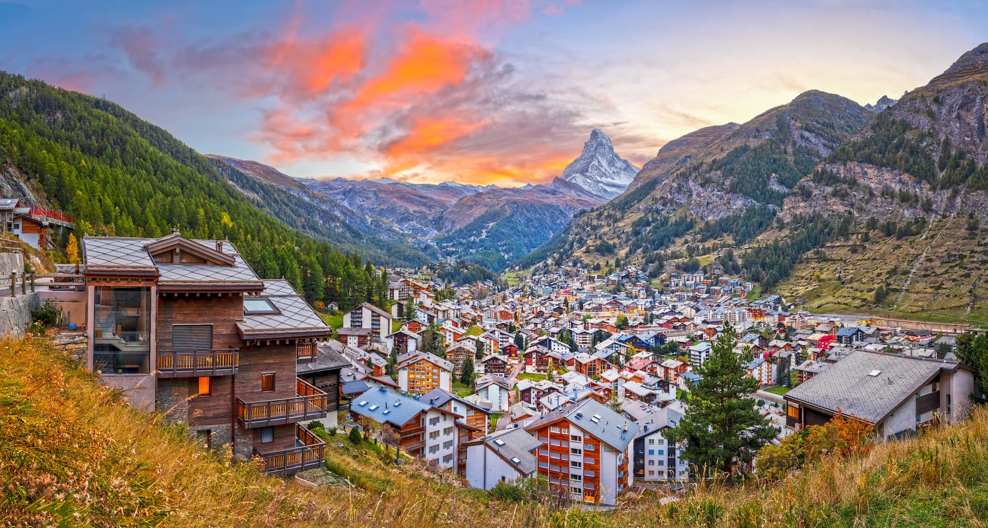 Alpine village of Zermatt nestled in valley with Matterhorn peak at sunset
