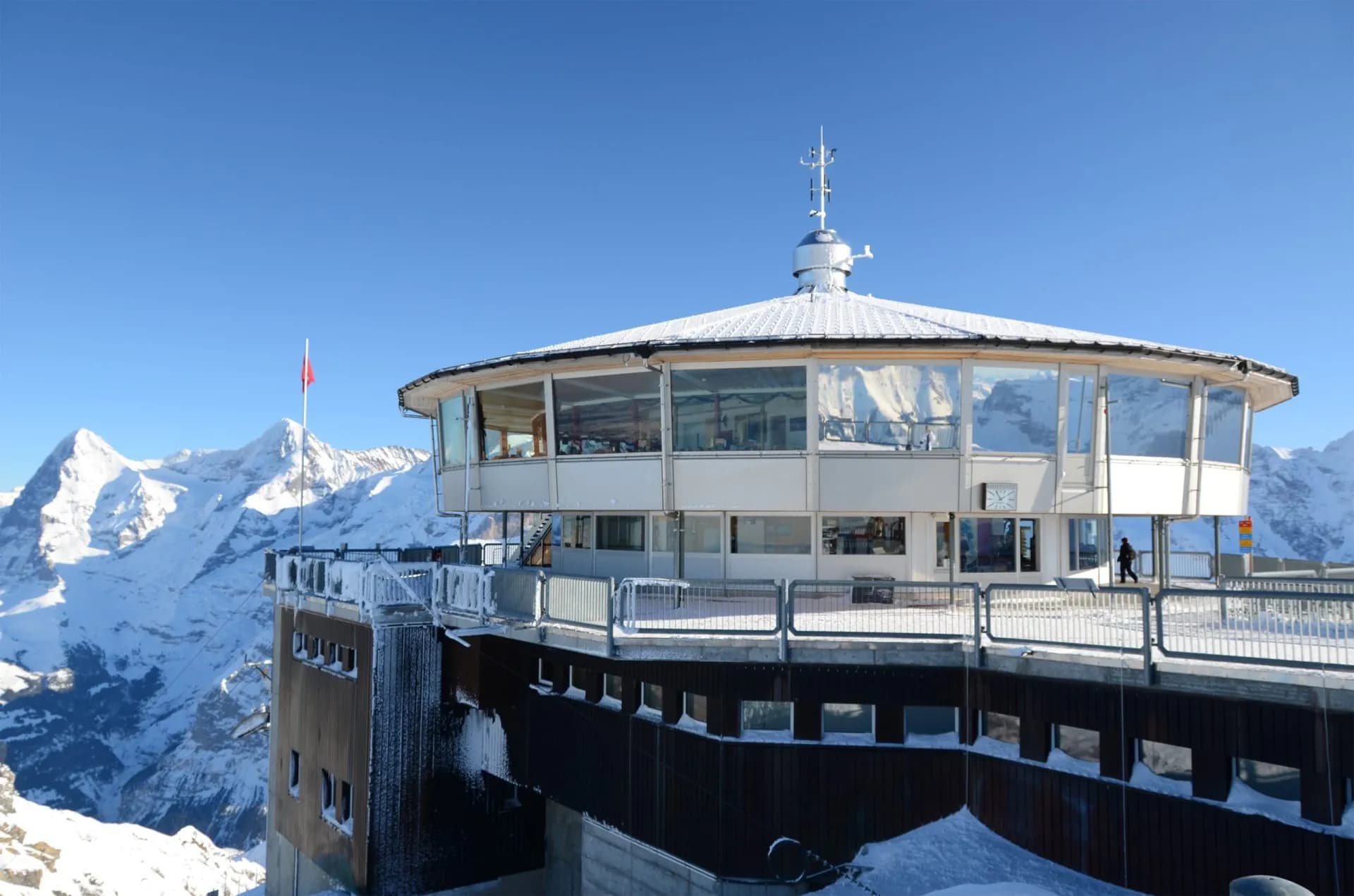 Revolving restaurant Piz Gloria with snow-covered Swiss Alps and clear blue sky